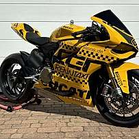 Eine gelbe Ducati-Rennmaschine mit auffälligem Design auf einem Ständer.