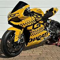 Eine gelbe Ducati-Rennmaschine mit auffälligem Design auf einem Ständer.