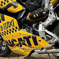 Detailansicht eines gelben Ducati Motorrads mit auffälliger Beschriftung.