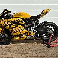 Eine gelbe Ducati Rennmaschine mit auffälligem Design auf einem Ständer.