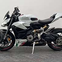 Einseitige Ansicht eines weißen Ducati V2 Motorrads auf grauem Boden.