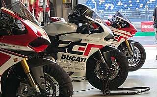 Drei Ducati Motorräder in einer Garage, bereit für das Rennen.