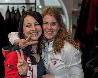 Zwei Frauen posieren lächelnd im Ducati-Shop.