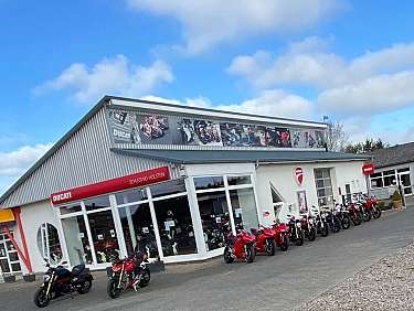 Ein Ducati Motorradgeschäft mit mehreren Motorrädern vor dem Gebäude.