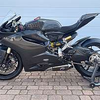 Ein schwarzes Sportmotorrad steht auf einem Ständer auf Pflastersteinen.