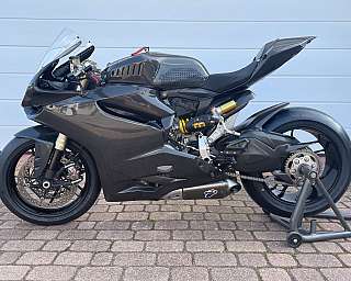 Ein schwarzes Sportmotorrad steht auf einem Ständer auf Pflastersteinen.