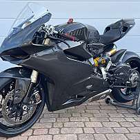 Ein schwarzes Sportmotorrad mit Carbon-Elementen auf einem Ständer.