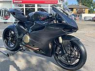 Ein schwarzes Ducati Rennmotorrad mit Carbon-Verkleidung und sportlichem Design.