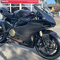 Ein schwarzes Ducati Rennmotorrad mit Carbon-Verkleidung und sportlichem Design.