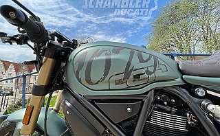 Detailaufnahme eines Ducati Scrambler Motorrads mit grünem Tank.