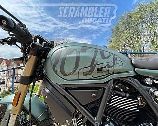 Detailaufnahme eines Ducati Scrambler Motorrads mit grünem Tank.