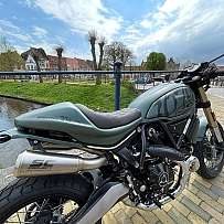 Ein Ducati Scrambler Motorrad am Ufer eines Kanals.
