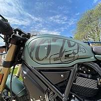 Nahaufnahme eines Motorrads mit einem speziellen Tankdesign und blauem Himmel.