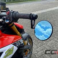 Detailaufnahme eines Motorradlenkers mit Spiegel und reflektierendem Himmel.