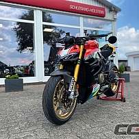 Ein sportliches Motorrad in leuchtenden Farben vor einem Verkaufsraum.