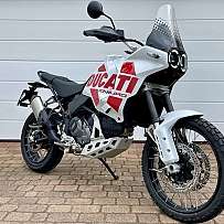 Ein Ducati Enduro Motorrad steht vor einer weißen Garagentür.