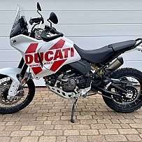 Ein Ducati Enduro Motorrad steht auf einem gepflasterten Boden.