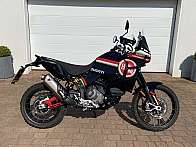 Ein Ducati DesertX Motorrad steht vor einer Garage.