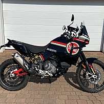 Ein Ducati DesertX Motorrad steht vor einer Garagentür.