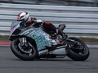 Ein Motorradfahrer fährt schnell auf einer Rennstrecke mit einer Ducati.