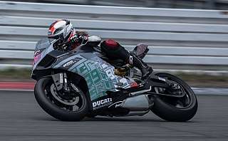 Ein Motorradfahrer fährt schnell auf einer Rennstrecke mit einer Ducati.