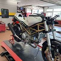 Ein Motorrad auf einem Werkstattständer in einer modernen Garage.