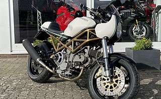 Ein Ducati Motorrad steht vor einem Ausstellungsraum mit anderen Motorrädern.