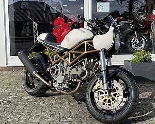 Ein Ducati Motorrad steht vor einem Ausstellungsraum mit weiteren Motorrädern.