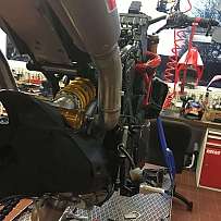 Ein Motorradmotor mit sichtbaren Komponenten in einer Werkstatt.