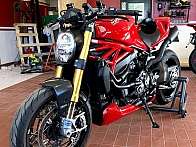 Ein rotes Ducati-Motorrad in einer Werkstatt mit Werkzeugen im Hintergrund.