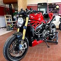 Ein rotes Ducati-Motorrad in einer Werkstatt mit Werkzeugen im Hintergrund.