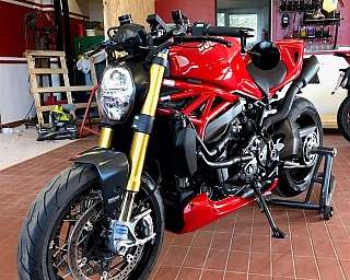Eine rote Ducati-Motorrad steht in einer Werkstatt.