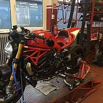Ein rotes Motorrad auf einem Werkstattständer zur Reparatur.