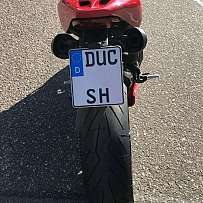 Rückansicht eines roten Ducati-Motorrads mit breitem Reifen.