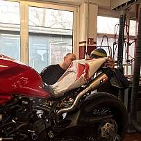 Zwei Mechaniker arbeiten an einer roten Ducati in einer Werkstatt.