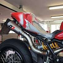 Detailaufnahme eines Motorrads mit modifiziertem Heck und Auspuffanlage.