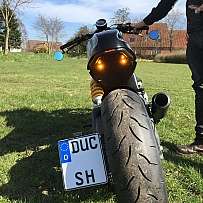 Ein Motorrad mit einem großen Hinterrad und einem Fahrer im Freien.