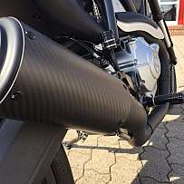 Nahaufnahme einer Motorrad-Auspuffanlage aus Kohlefaser.