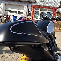 Detailaufnahme eines Motorrads mit schwarzem und silbernem Design im Freien.