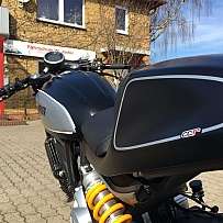 Ein Motorrad mit modernem Design vor einer Fahrschule.