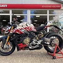 Ein Ducati Motorrad steht vor einem Verkaufsraum mit Schaufenster.