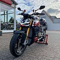 Ein sportliches Motorrad steht auf einem Ständer vor einem Verkaufsraum.