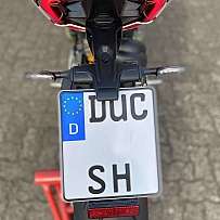 Rückansicht eines Motorrads mit deutschem Kennzeichen und LED-Rücklicht.