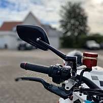 Detailaufnahme eines Motorradlenkers mit Spiegel und Bremshebel.