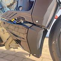 Detailaufnahme eines Motorradmotorbereichs mit Verkleidungsteilen.