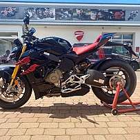 Ein schwarzes Ducati Motorrad mit rotem Sitz auf einem Ständer.
