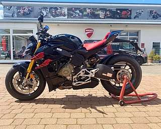 Ein schwarzes Ducati Motorrad mit rotem Sitz auf einem Ständer.