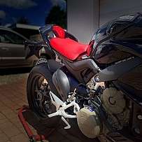 Nahaufnahme einer Ducati mit rotem Sitz und Motorradständer.