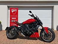 Ein rotes Ducati Motorrad steht vor einer weißen Garage.