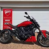 Ein rotes Ducati-Motorrad vor einer weißen Garage.